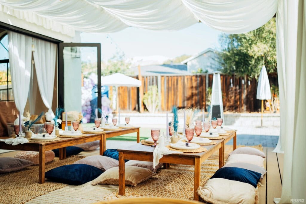 Boho chic, low-lying tables are decorated for a small outdoor gathering