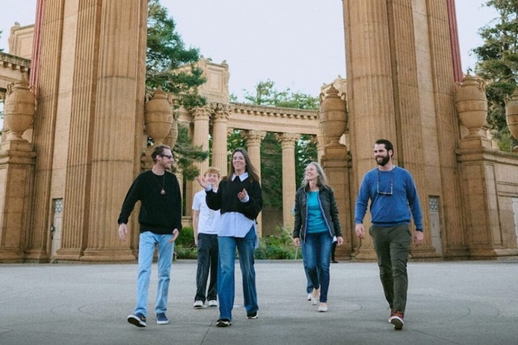 A group of people walk through an exterior area at The Palace of Fine Arts