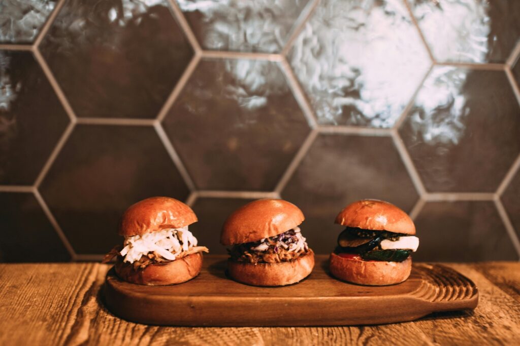 three sliders on a wood cutting board