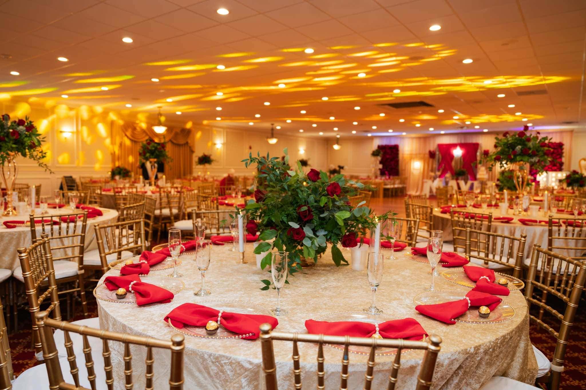 Upscale Boston party venue with gold Chiavari chairs and red rose centerpieces