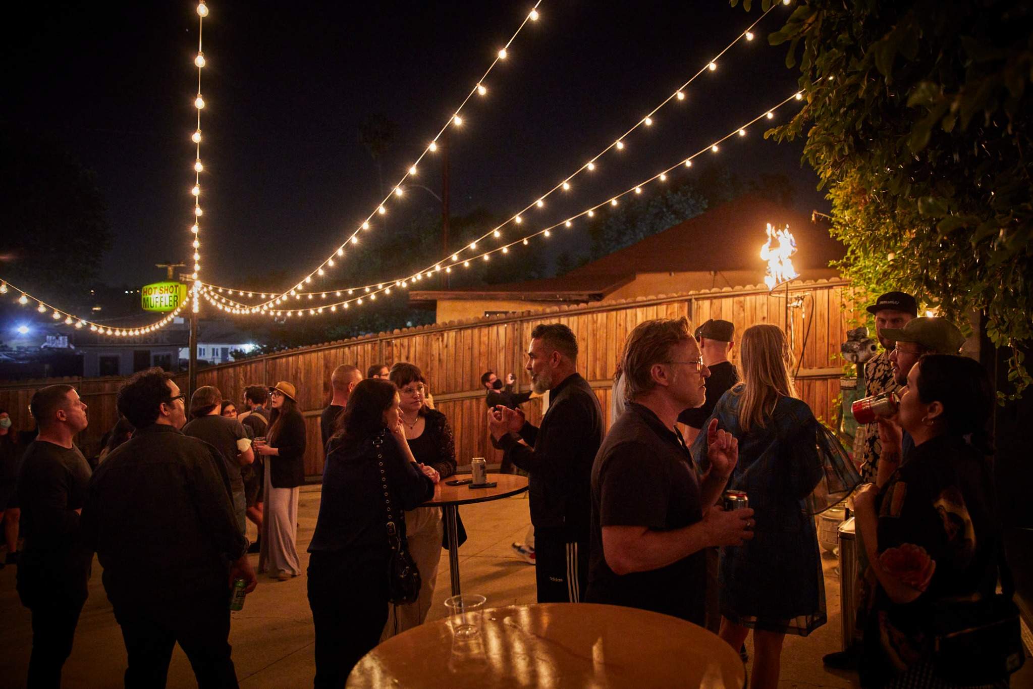 Outdoor California evening party with string lights and mingling guests