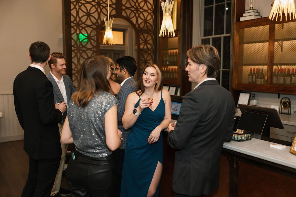 Formally dressed professionals networking at a Cincinnati cocktail party