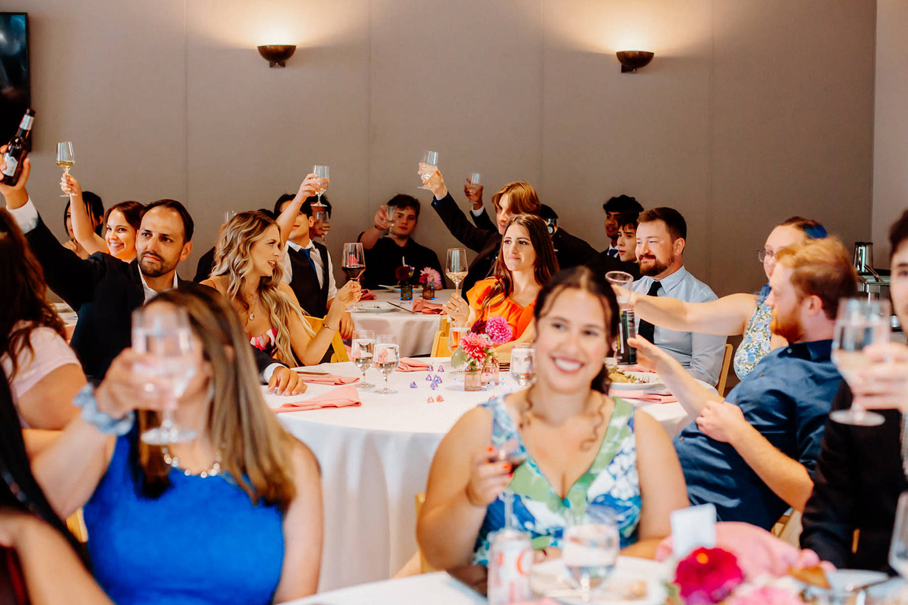 Elegantly dressed guests raising champagne glasses at Detroit celebration