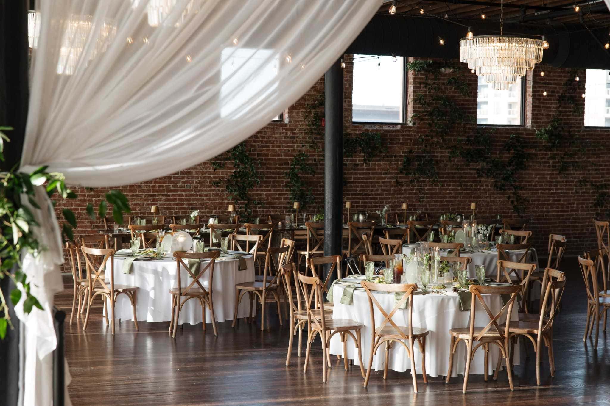 Refined indoor Kansas reception venue with round tables and chandelier