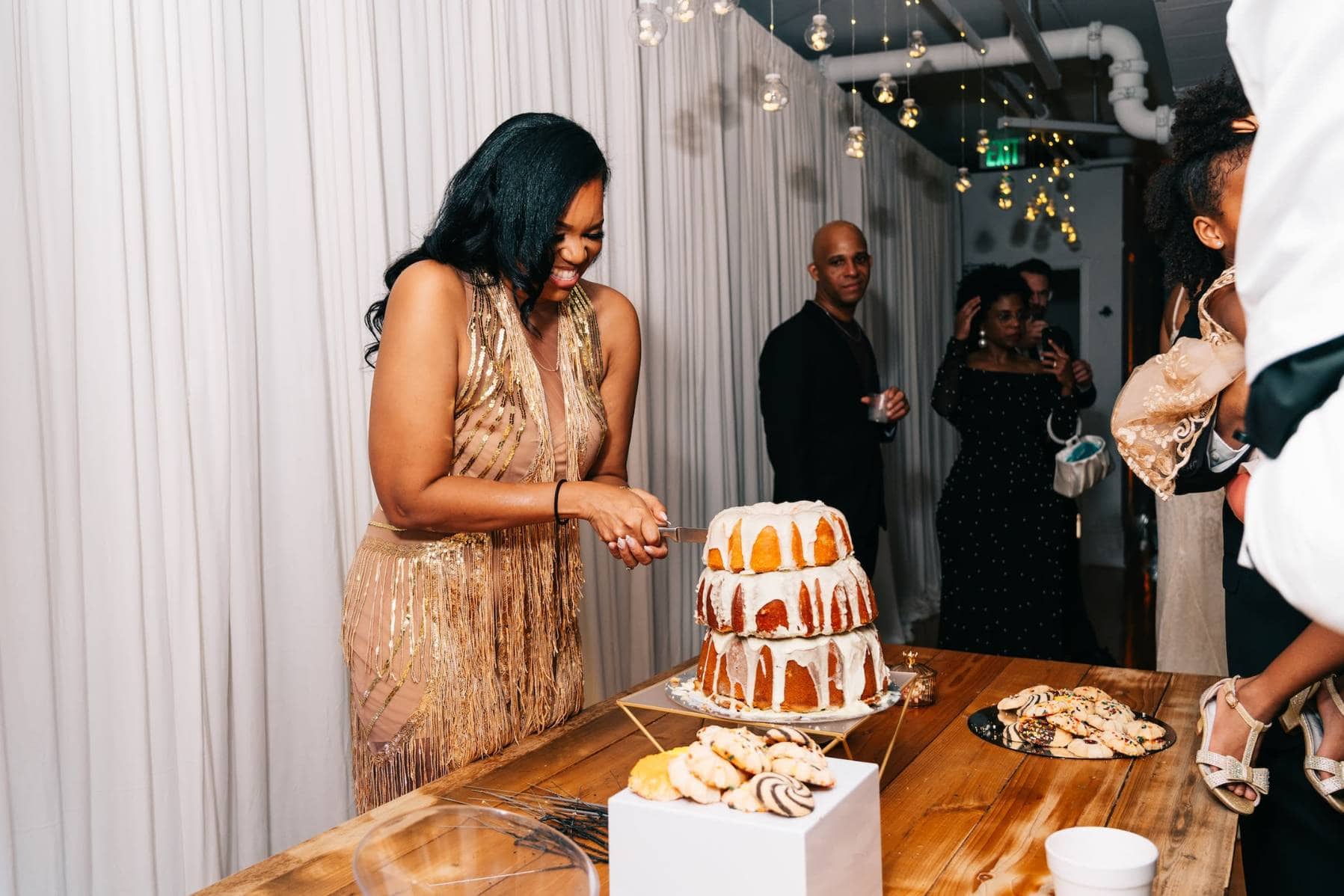 Woman cutting tiered cake at upscale Memphis celebration event