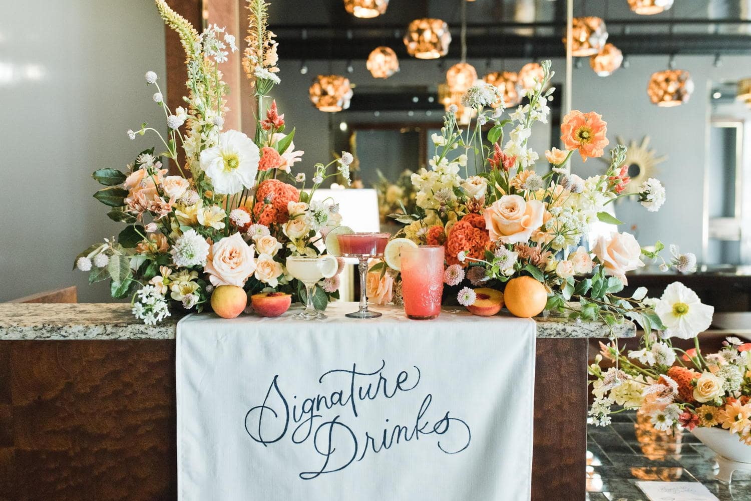 Styled signature drink station with florals at Memphis party