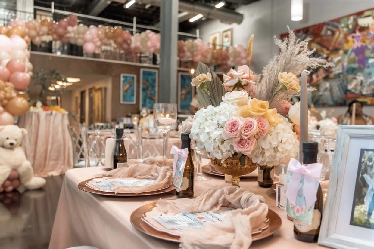 Elegant tablescape with floral arrangements and balloons for New Orleans party