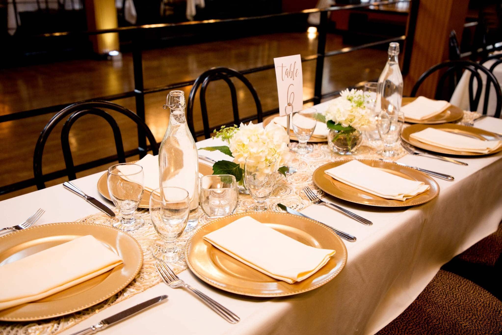 Formal Seattle reception table with gold settings and hydrangea centerpieces