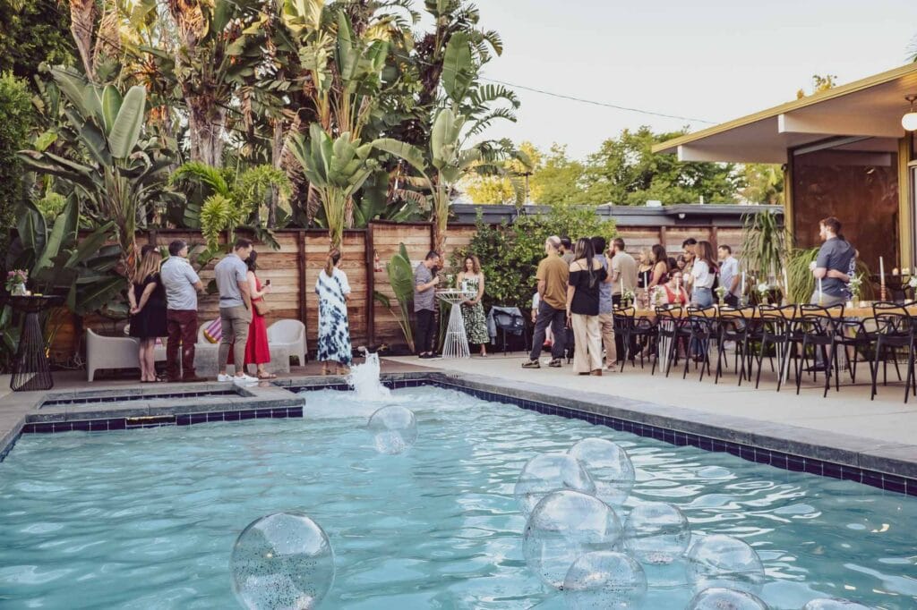 Outdoor party in Florida with pool, palm trees, and guests planned by Tampa party planner