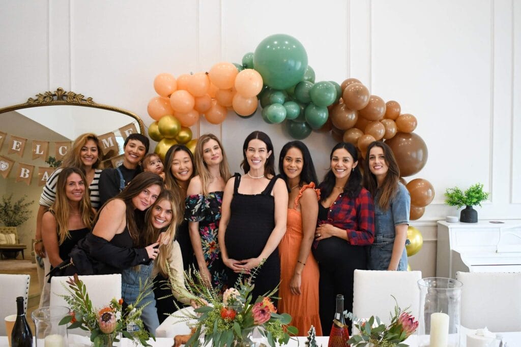 Friends standing under balloon arch at party designed by Tampa planner