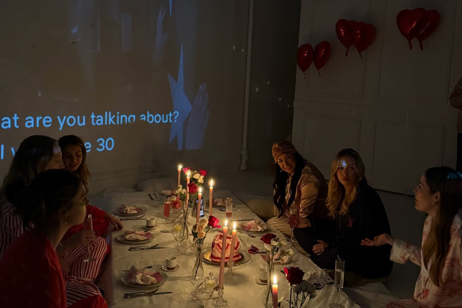 Intimate Tulsa dinner party with romantic candles and heart balloons