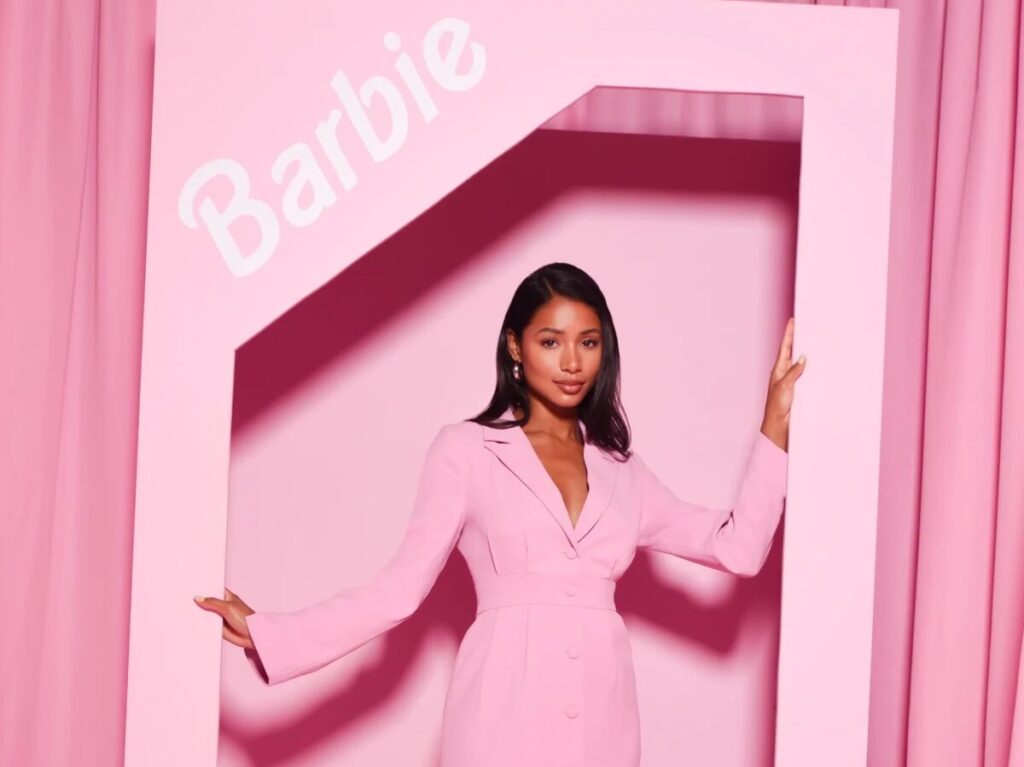 Woman dressed in pink posing in Barbie backdrop for Galentine's theme