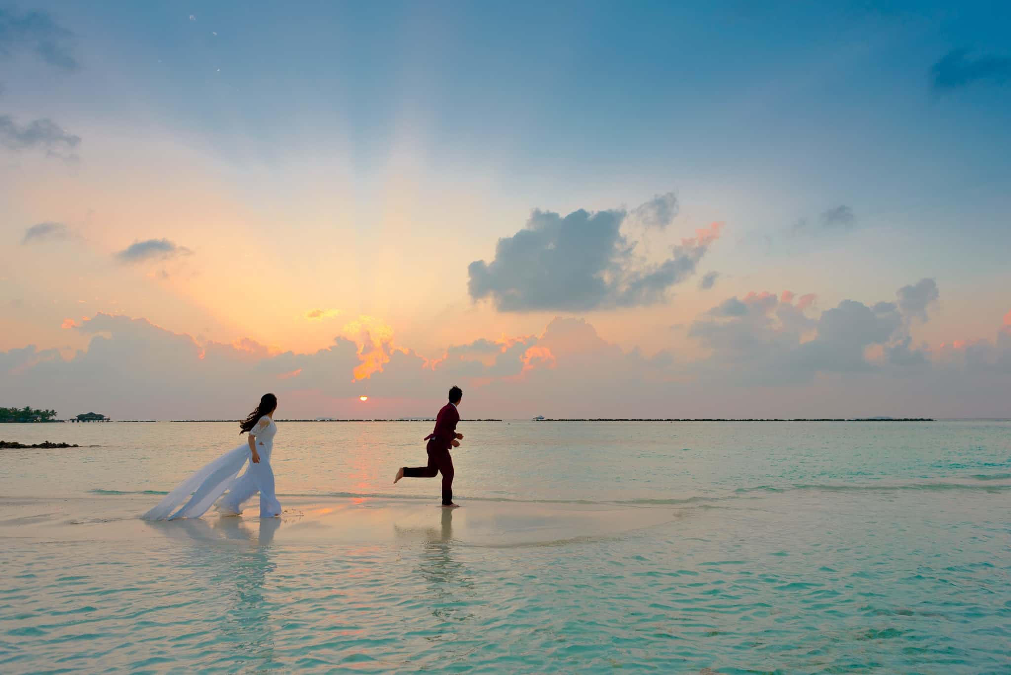 man and woman running on beach