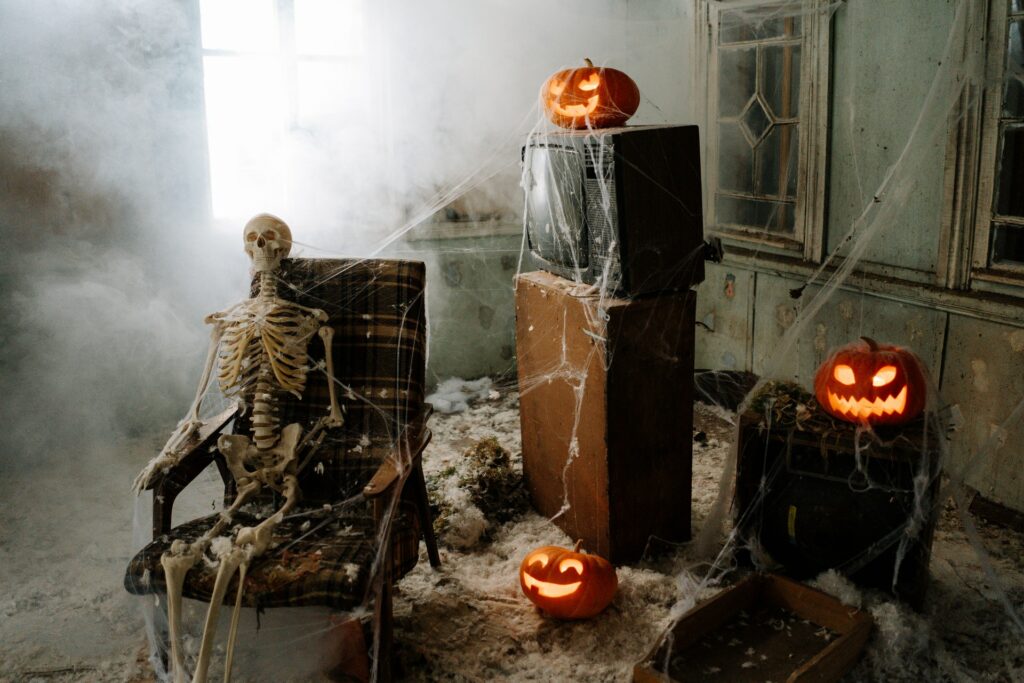 fake spiderwebs and jack o lanterns with fake skeleton