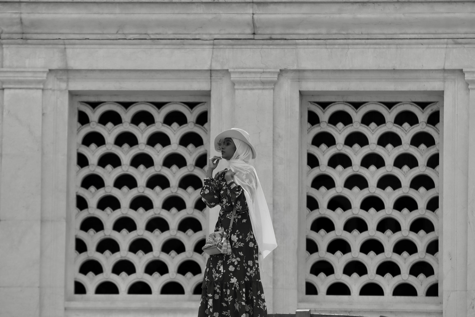 black and white photo of a woman standing in front of a wall