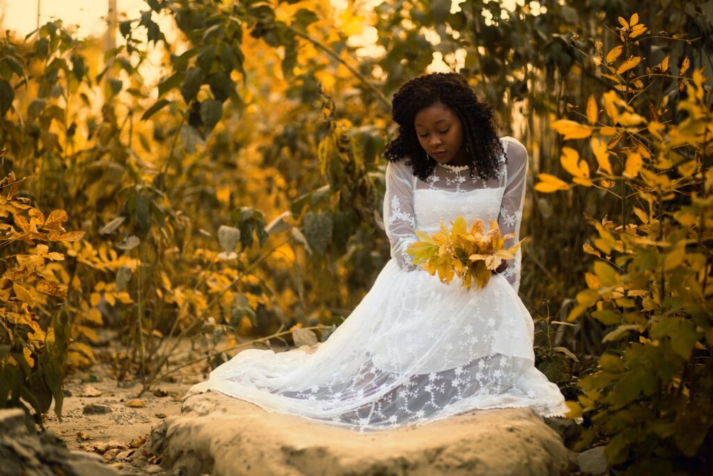 bride sitting on autumn leaves