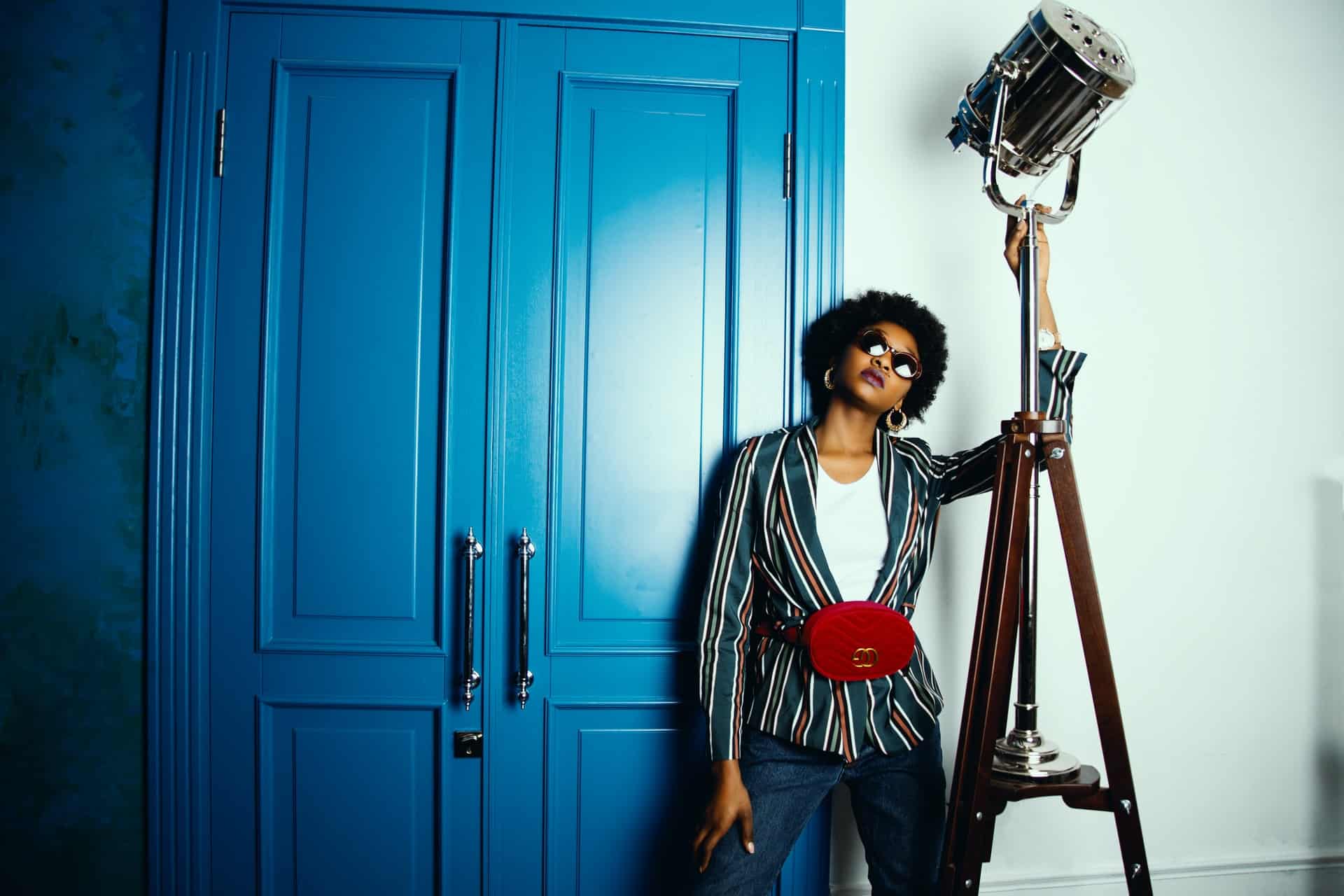 lady in sunglasses posing against blue doors