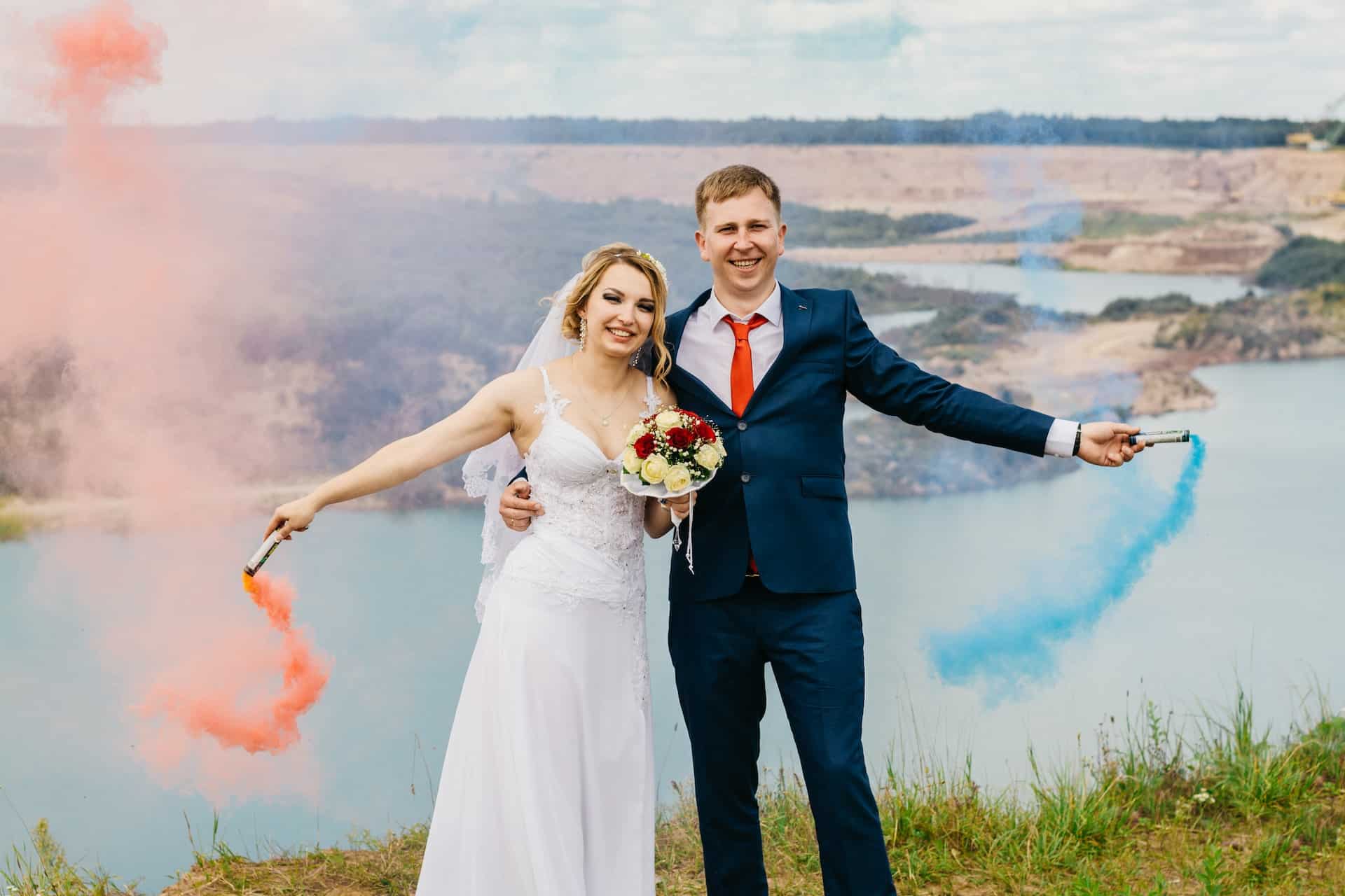 bride and groom holding colored flares