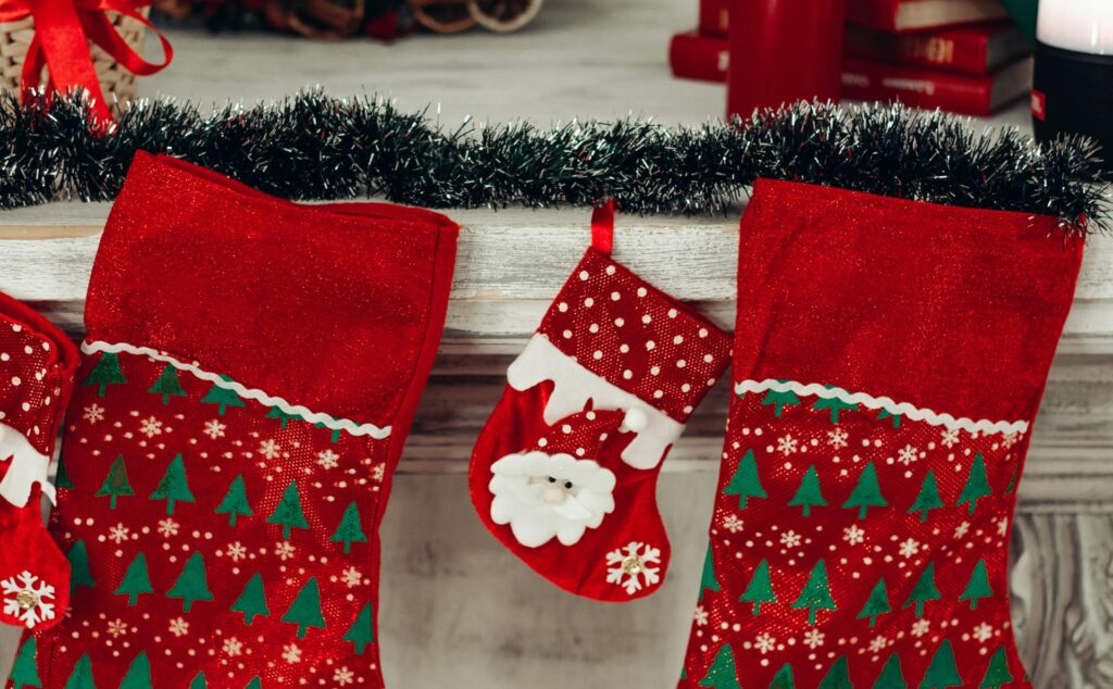 Stockings hung on mantel with one small one for Christmas gender reveal