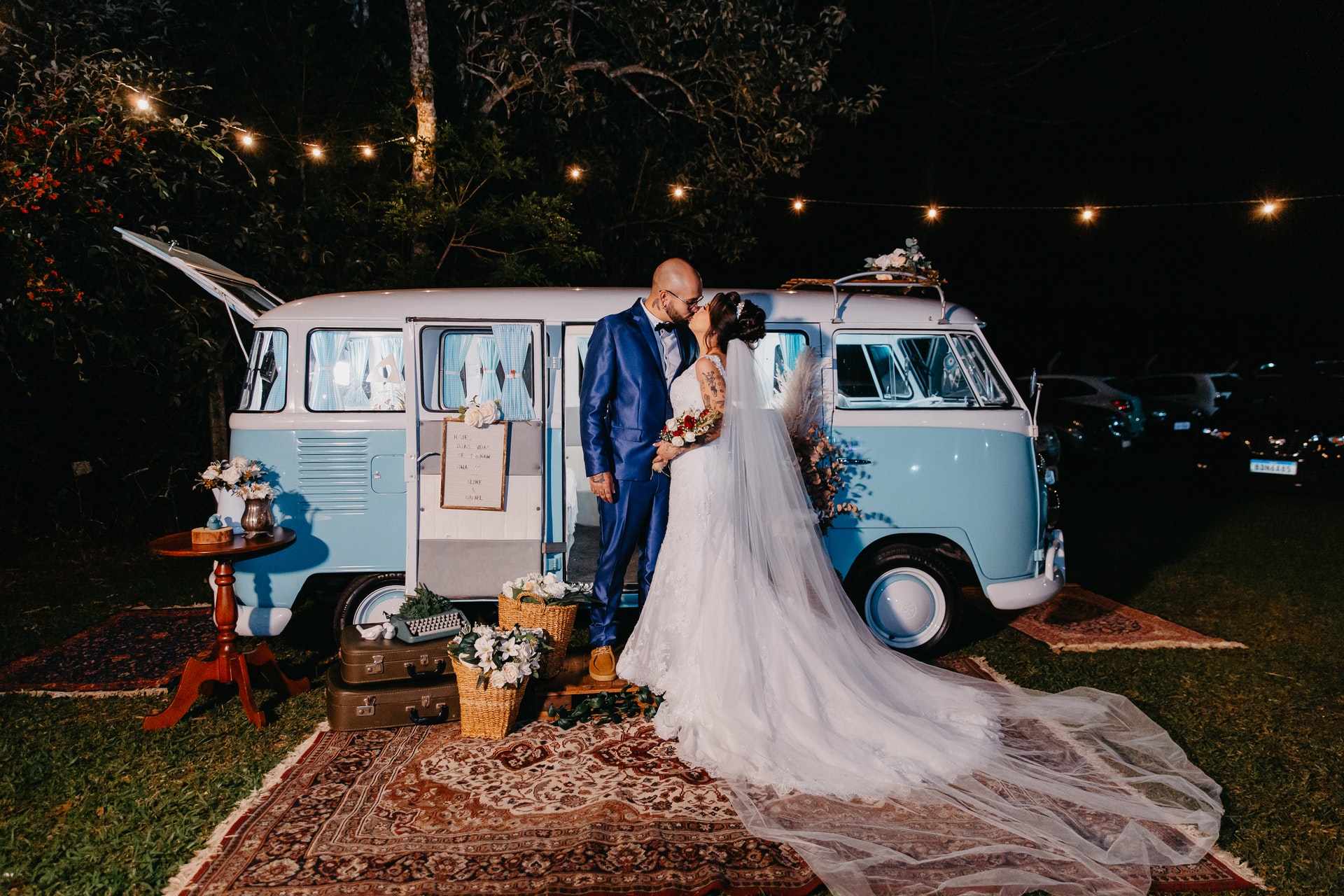 bride and groom kissing in front of bus