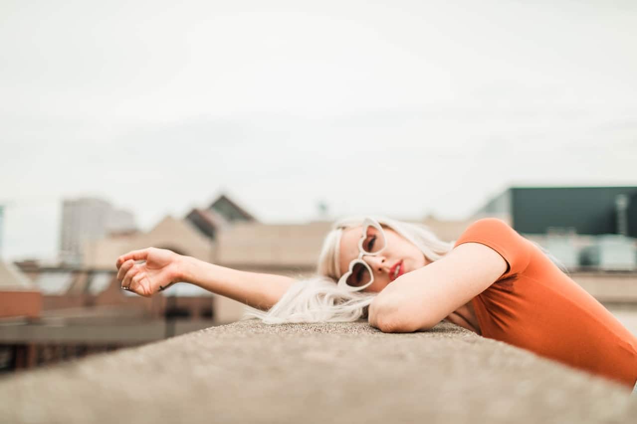 woman leaning against a flat surface on a rooftop