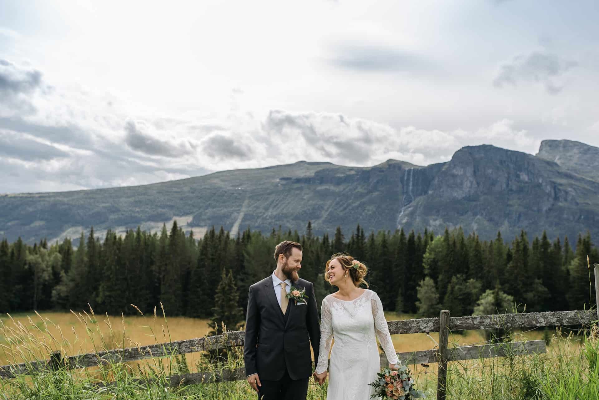 bride and groom holding hands in front of mountains