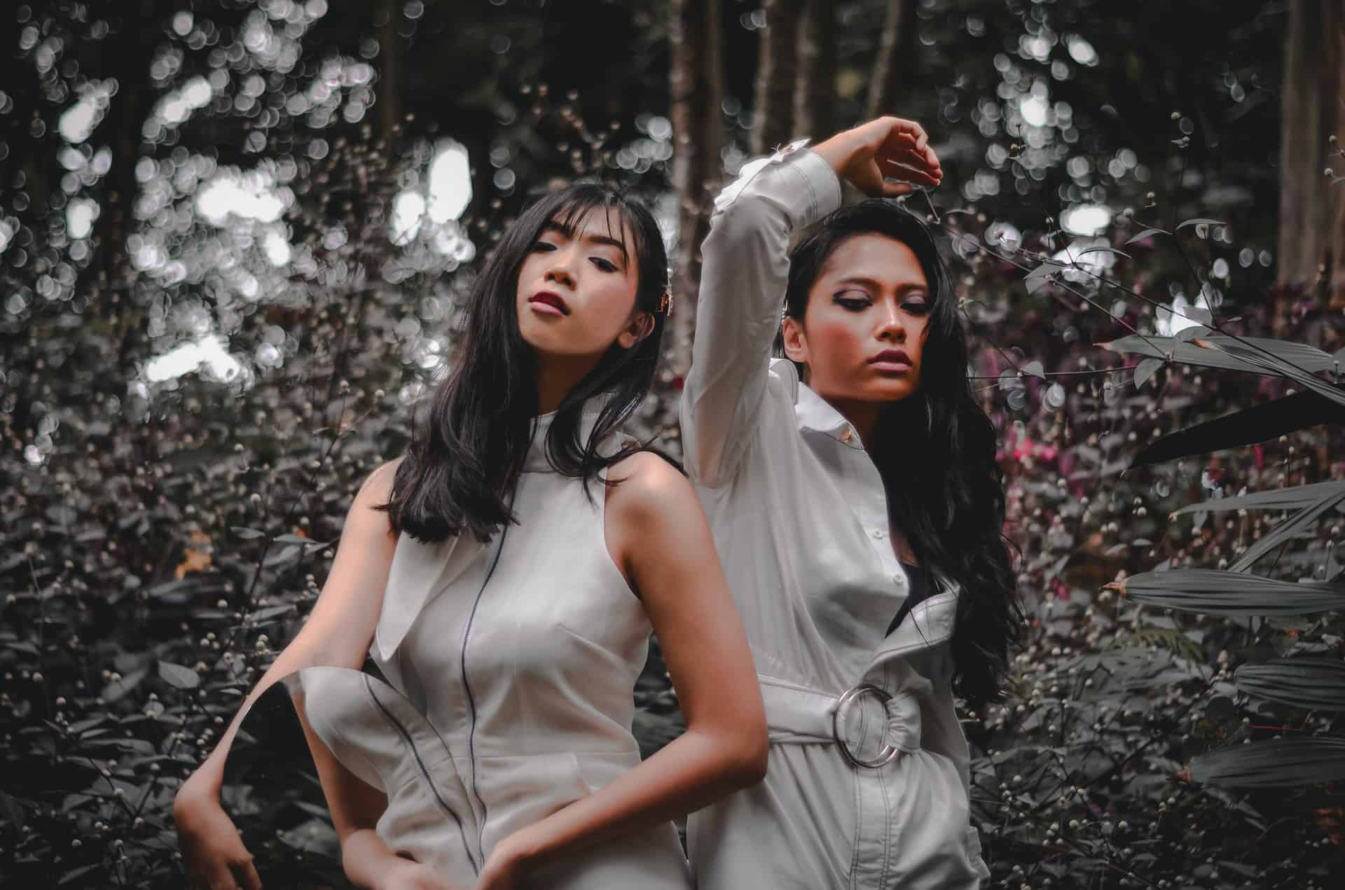 two girls posing for a photo in a garden