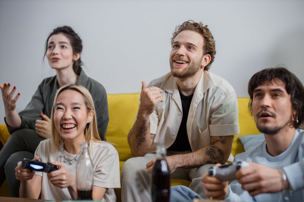 Four friends playing an interactive Friendsgiving game with controllers on the couch