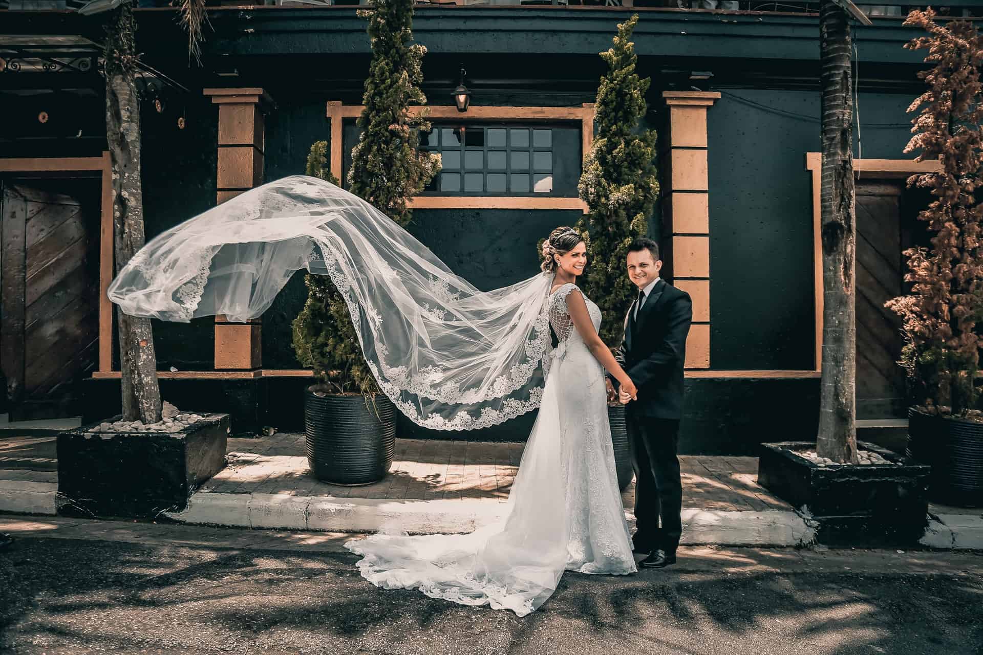 bride and groom standing on street and smiling