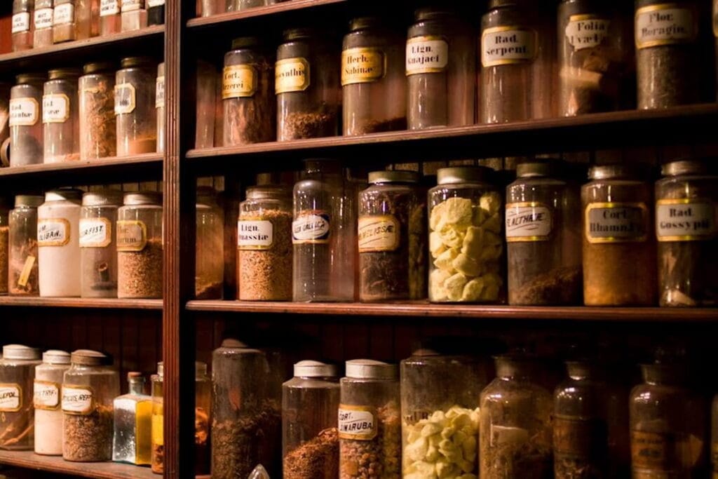 A wall of shelves holding pharmaceuticals in canisters from a bygone era