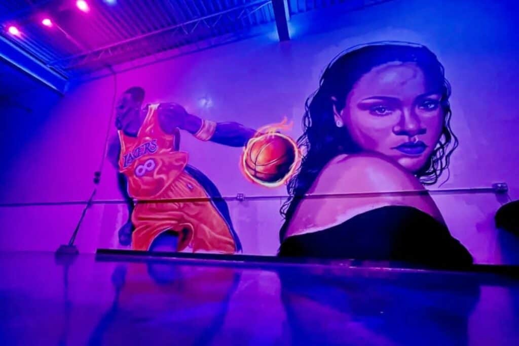 a warehouse wall graiffitied with kobe bryant and rhianna