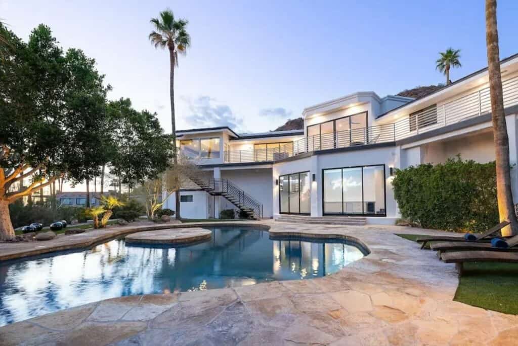 a mansion with a pool and palm trees