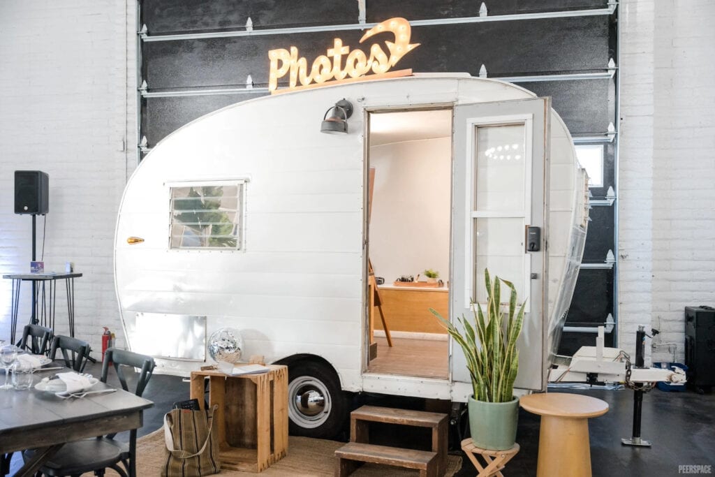 A mini camper doubles as a photo booth at a wedding reception