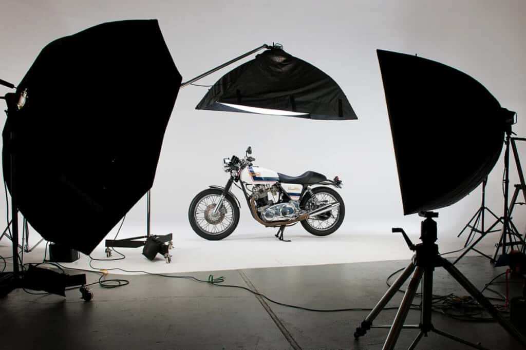 A professional studio space in Pittsburgh with lighting equipment and a white cyclorama with a motorcycle as the subject