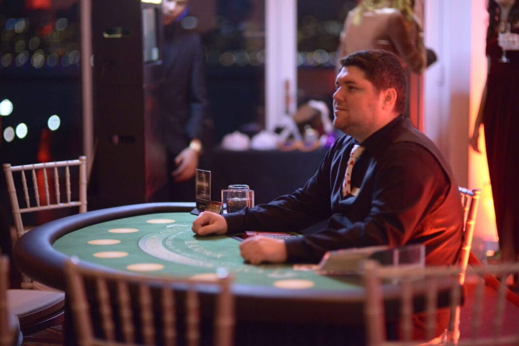 A dealer sits at an empty poker table