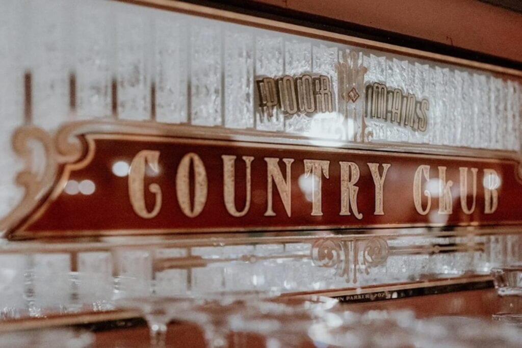 Close up shot of sign behind bar at Tom Archer's Poor Man's Country Club in Des Moines