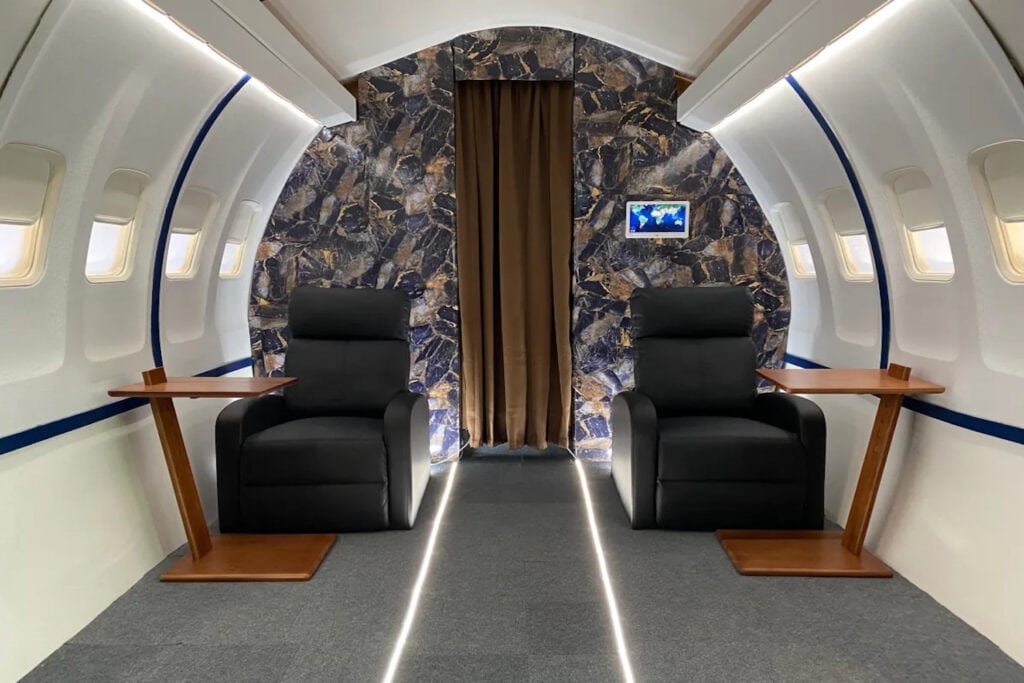 Film set of a private jet with two chairs and tables