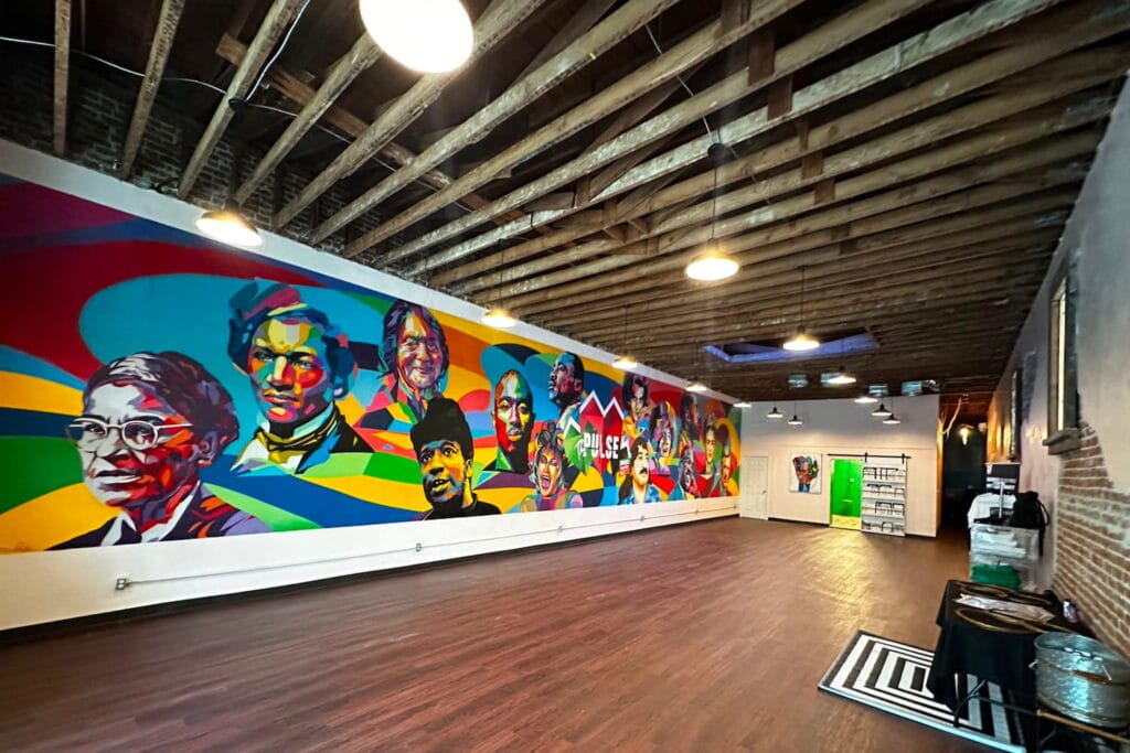 A brightly-colored mural of famous faces covers the main wall of a gallery in San Bernadino