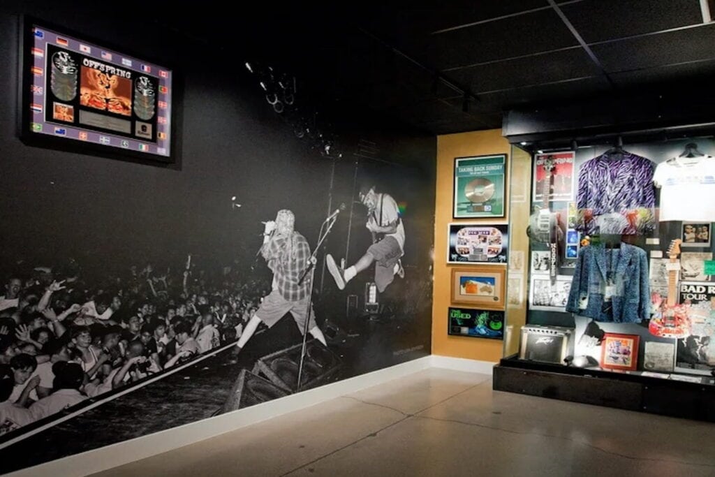 A large mural of a band playing next to a display of music memorabilia