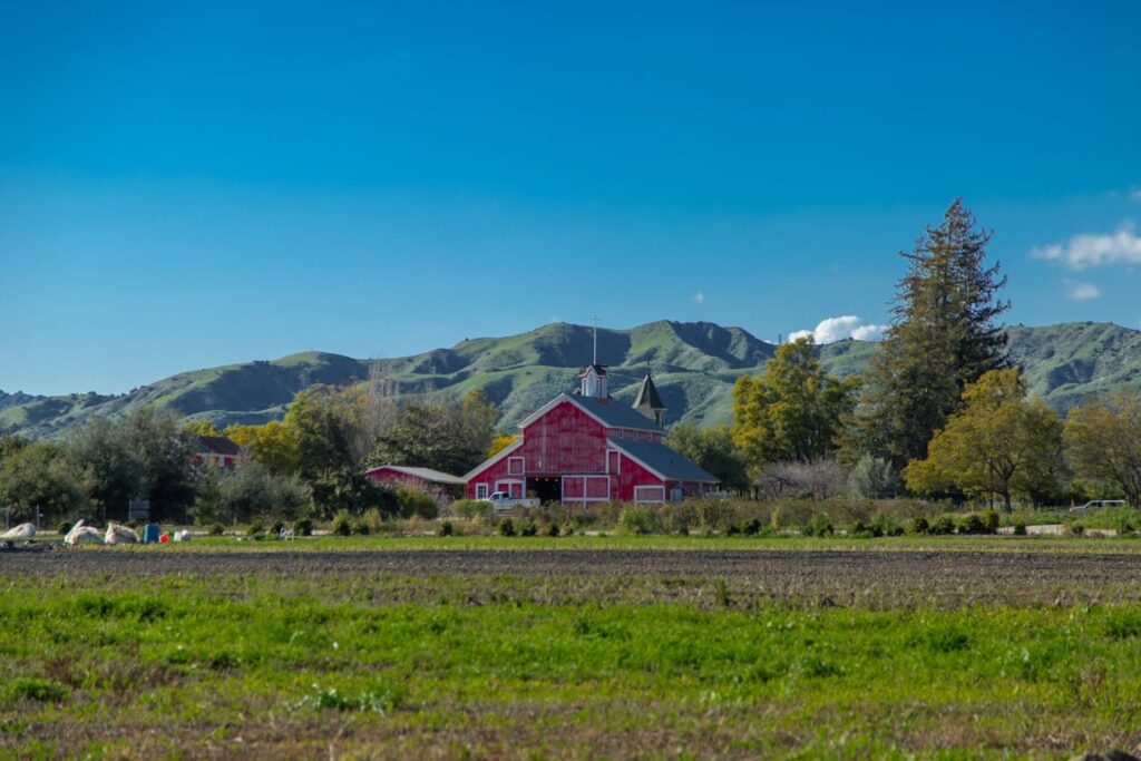 A red barn sits on farmland in the California countryside