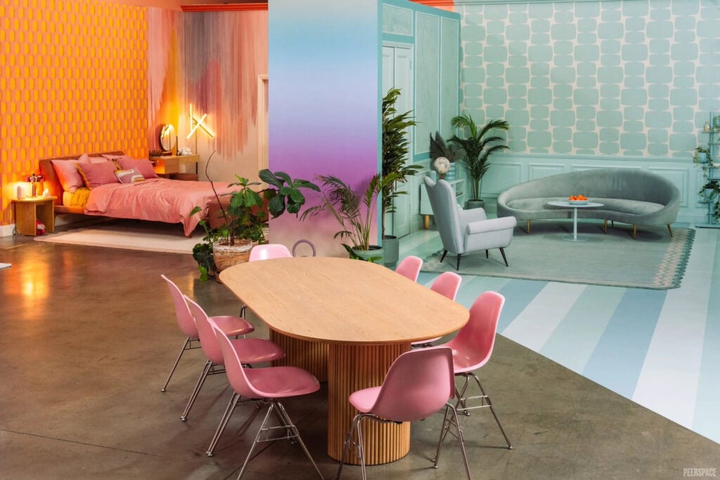 Retro film set with pink dining chairs, seafoam green living room and orange bedroom