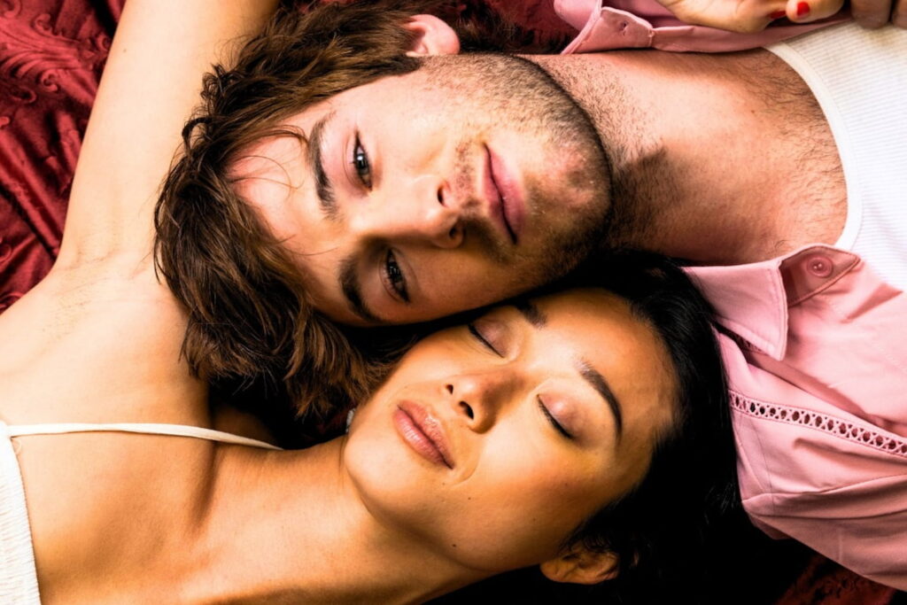 A man and woman lying with their heads together