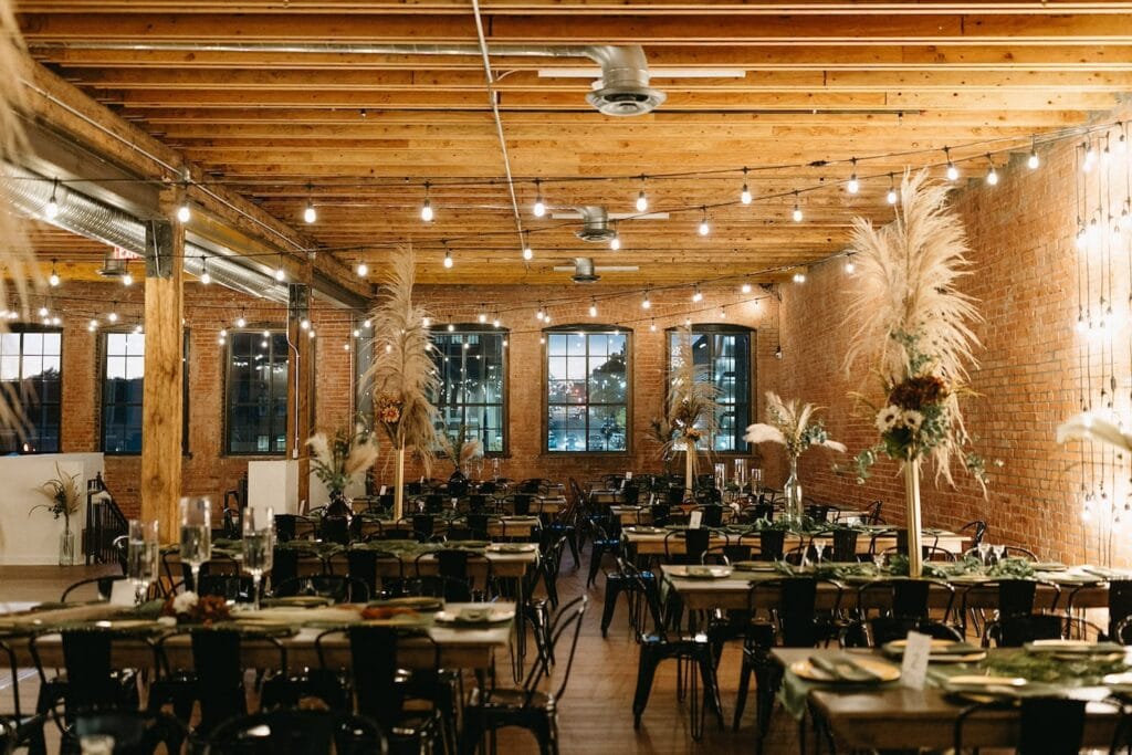 A rustic event space is outfitted for a large dinner party