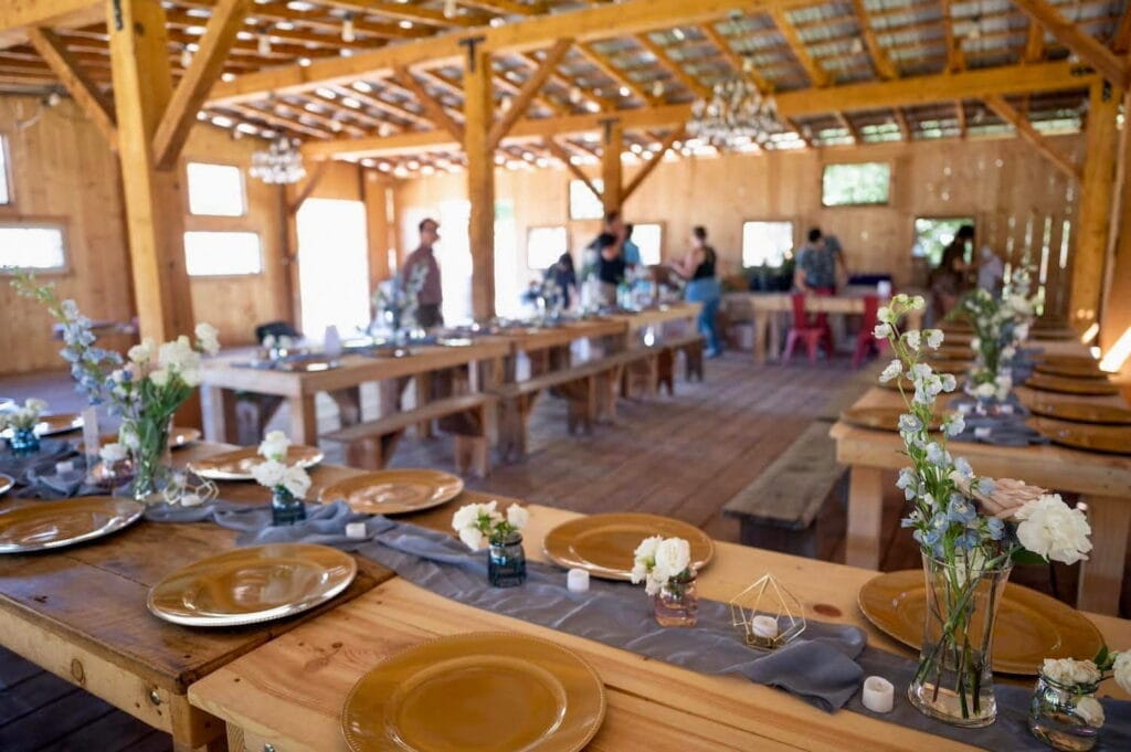 Rustic venue set up with long wooden tables for a reception