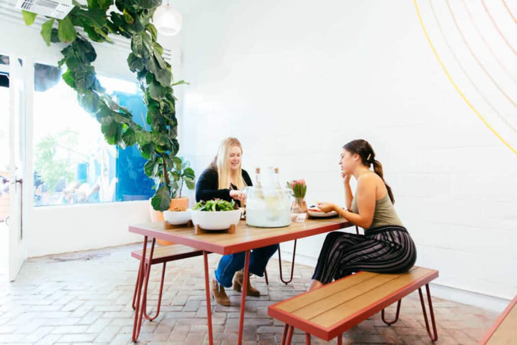 two women sitting at a picnic table in a houston cafe