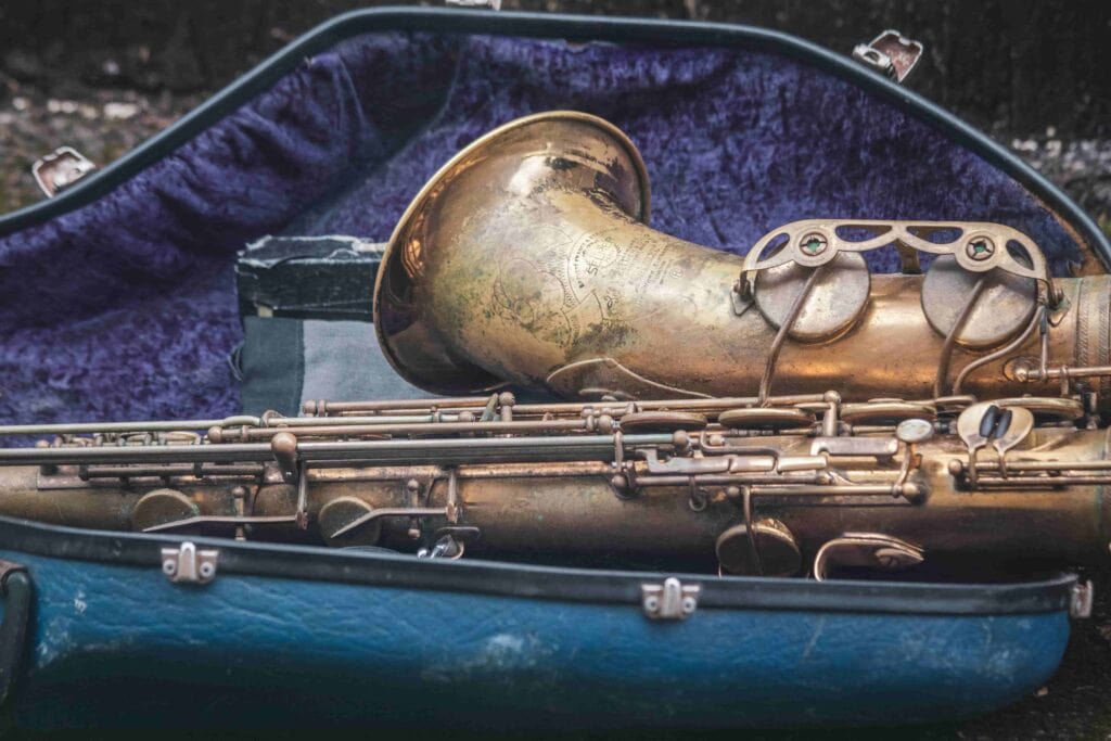A well-worn saxophone sits in a velvet case