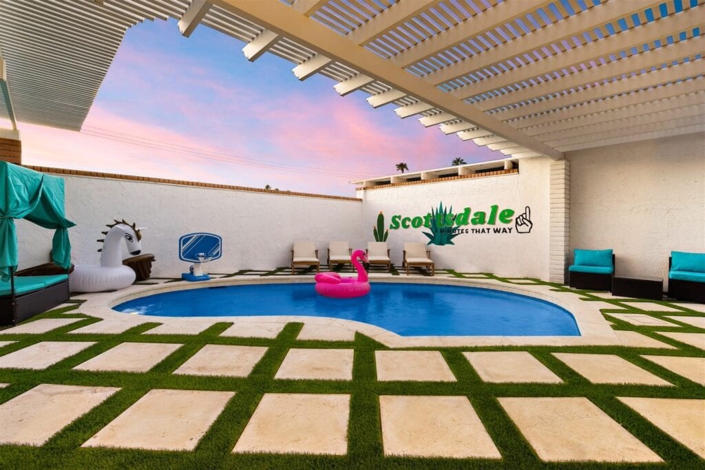 A giant pink flamingo float sits in a pool in the backyard of a house in Scottsdale, AZ