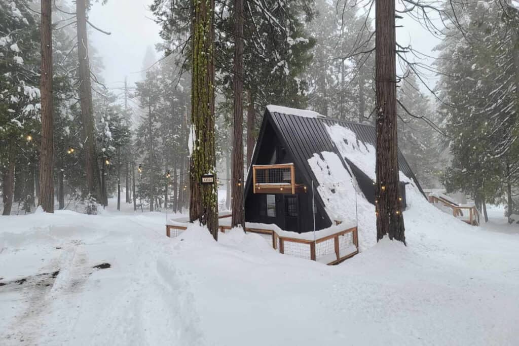 an a-frame cabin in the snowy woods