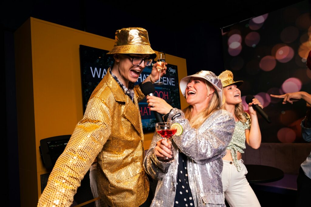 People in sparkly outfits singing karaoke at a divorce party