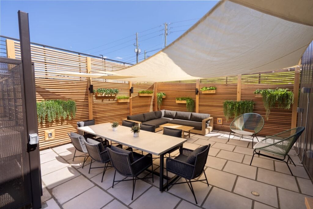 Small outdoor rooftop patio with a table and chairs and a seating area
